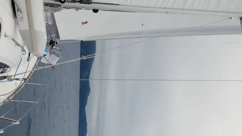 A sailboat is on the water with a cloudy sky in the background Stock Footage 276072662