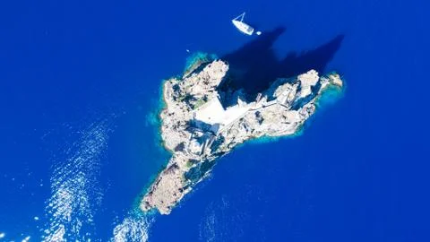 Sailboat while cruising, sailing at opened sea. Island with Lighthouse in bea Stock-Fotos