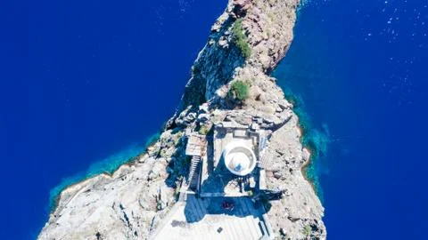 Sailboat while cruising, sailing at opened sea. Island with Lighthouse in bea Stock-Fotos
