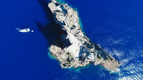 Sailboat while cruising, sailing at opened sea. Island with Lighthouse in bea Stock-Fotos
