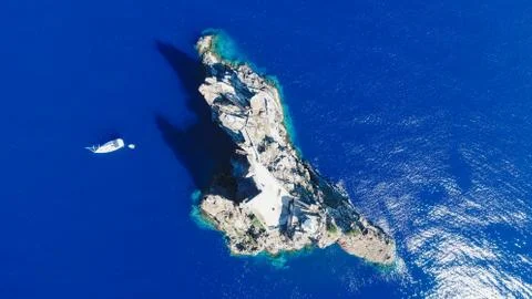Sailboat while cruising, sailing at opened sea. Island with Lighthouse in bea Stock-Fotos