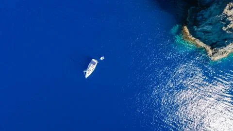 Sailboat while cruising, sailing at opened sea. Island with Lighthouse in bea Stock-Fotos
