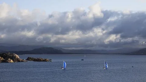 Sailboats and dramatic clouds, evening in the Mediterranean sea, La Maddalena 写真素材