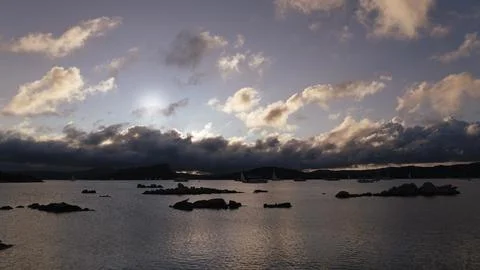 Sailboats and dramatic clouds, evening in the Mediterranean sea, La Maddale.. Stock Photos
