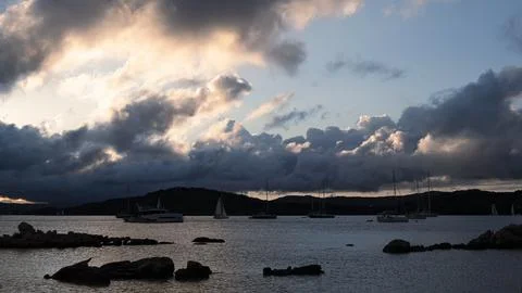 Sailboats and dramatic clouds, evening in the Mediterranean sea, La Maddale.. Stock Photos