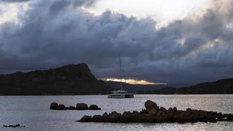 Sailboats and dramatic clouds, evening in the Mediterranean sea, La Maddale.. Stock Photos