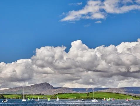 Sailboats on a lake beneath dramatic clouds 스톡 사진