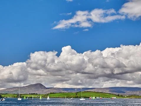 Sailboats on lake beneath dramatic cloudscape Stock Photos