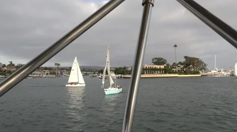 Sailboats waiting for race as seen from bimini top in the foreground harbor  Stock Footage