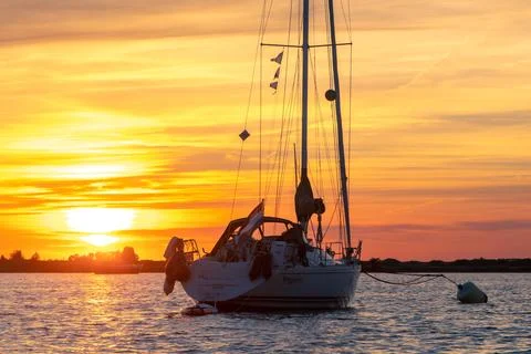 Sailing boat anchored with dramatic sunset Stock Photos