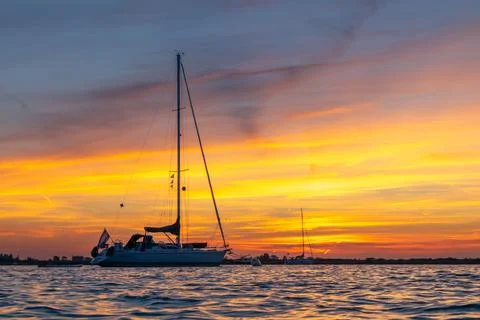 Sailing boat anchored with dramatic sunset Stock Photos