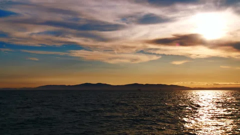 A sailing boat floats along the waves in the orange light of the evening sunset Stock Footage 92205558