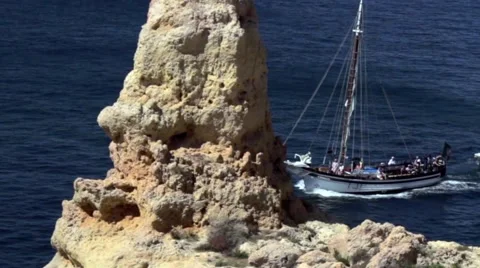 Sailing boat sails between rocks of the Atlantic coastline Stock Footage 65015659