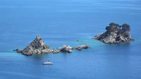 Sailing boat sails between the rocks in the sea Stock Footage 114016773