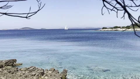 SAILING BOAT THROUGH FRAME BLUE SEA Stock Footage 202172353