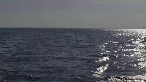 Sailing boats on sparkling water of river during sunset Stock Footage