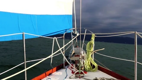 Sailing, bow, deck and headsail, land, overcast Stock Footage 78114819
