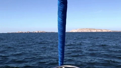 Sailing, the bow in foreground, island in background Stock Footage 78073736