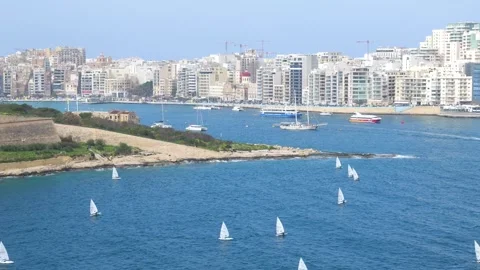 Sailing dinghies cluster closer together sliema skyline and fort manoel bastion Stock Footage 341805423