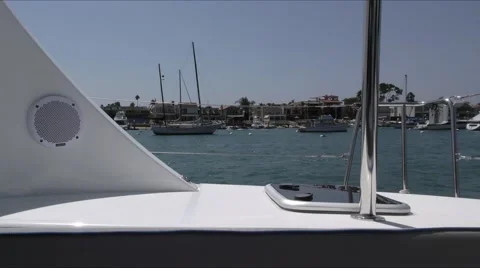 Sailing in harbor on catamaran looking from starboard aft area to moored boat Video stock 67490887