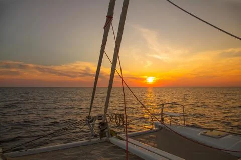 Sailing holidays: sunset with horizon while cruising with a sailboat on the o Stock Photos