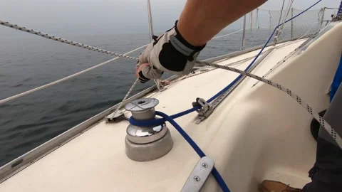 Sailing, man pulling ropes, winding sheets around winches. close-up. real time Stock Footage 155923447