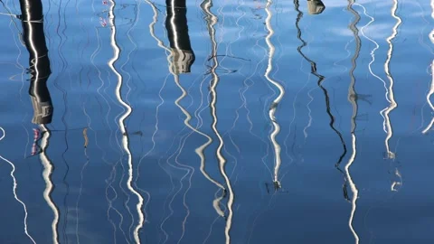 Sailing masts reflecting in calm sea water Stock Footage 338124310
