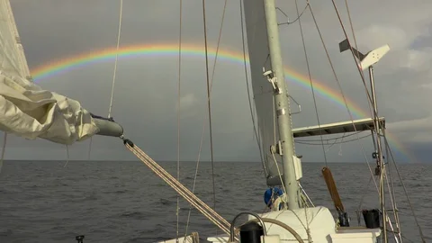 Sailing in open ocean with a rainbow Stock Footage 107926415