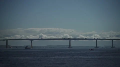 Sailing Parallel to a Busy Bridge on a Clear Blue Sea Stock Footage 256000288