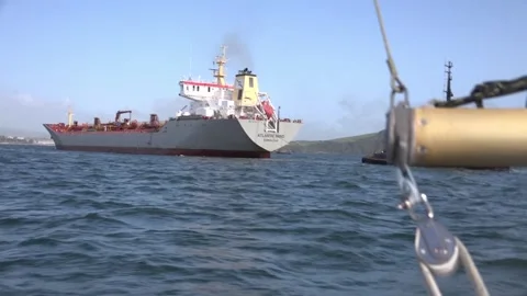 Sailing past a cargo ship outside Plymouth Harbour Stock Footage 255837171