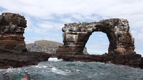 Sailing past dramatic cliffs near darwin's arch in the Galapagos Stock Footage 312095657