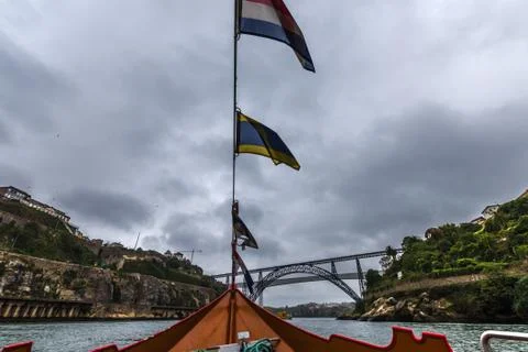 Sailing in Porto under the bridges in a boat with flags Stock Photos