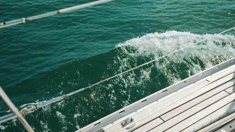 Sailing on the sea on a summer's day. Waves crashing on bow side of boat. 库存影片 137456728