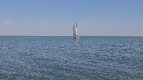A sailing ship is in the calm waves of the ocean in calm weather Stock Footage 86429424