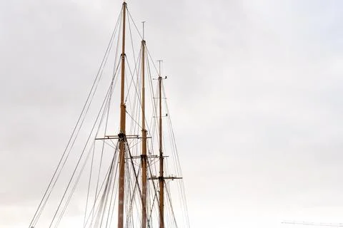 Sailing ship masts and rigging against cloudy sky Stock Photos