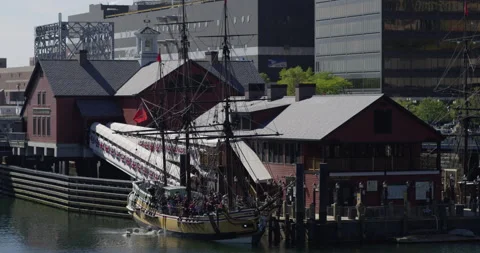 Sailing ship moored in a city dock with tourists on board throwing boxes Stock Footage 144984084