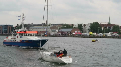 Sailing ship next to fun fair at Rostock Harbor during Hanse Sail weekend. 스톡 동영상 67574489