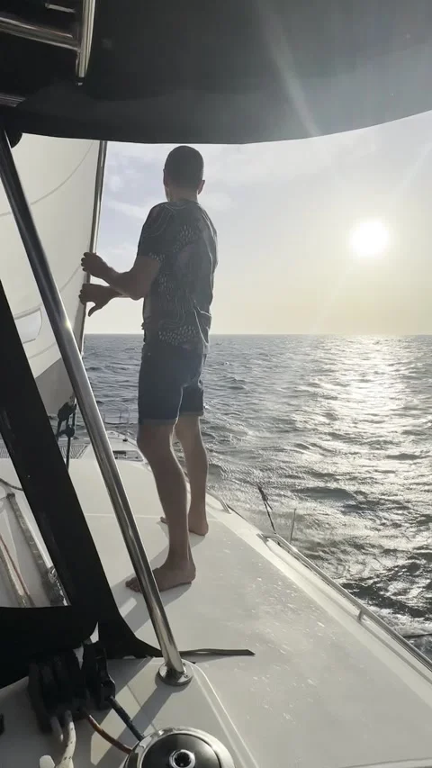 Sailing at Sunset with Man Catching Wind on Catamaran Stock Footage 336964927