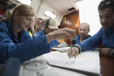 Sailing team plotting course at map on sailboat Fotos de archivo
