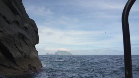 Sailing through a rocky gap along the coastline of Hirta, St Kilda Stock Footage 229759686
