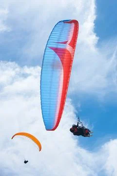 Sailing through the sky. two people paragliding on a sunny day. Stock Photos