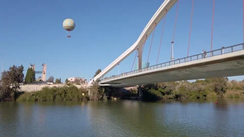Sailing under Barqueta Bridge over River Guadalquivir in Seville Stock Footage 329870119