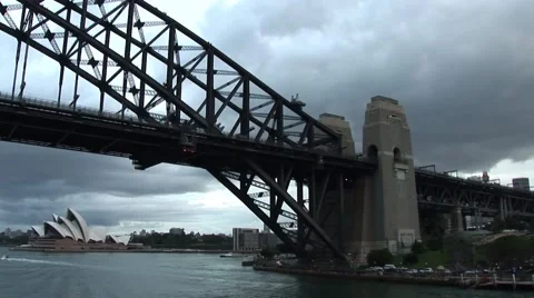 Sailing under Sydney Bridge cloudy day Stock Footage 52613360