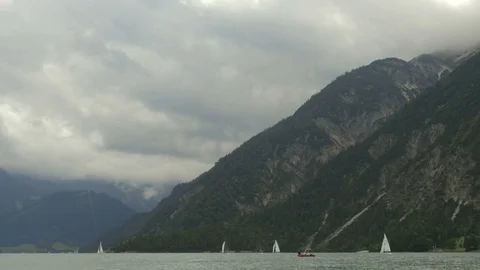 Sailing on the waves in lake between the mountains in the cloudy day Stock Footage 81935528