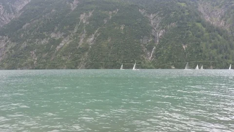 Sailing on the waves in the mountain lake in the rainy day Stock Footage 81936282