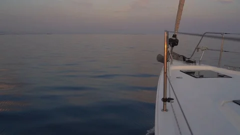 Sailing yacht forward view making way thru the water at sunset Stock Footage 120256105
