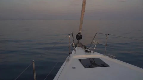 Sailing yacht forward view making way thru the water at sunset Stock Footage 120256117