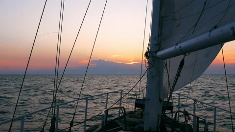 A sailing yacht is going towards the setting sun Stock Footage 140393364