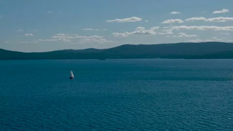 Sailing yacht on the lake, mountains background, 4k Stock Footage
