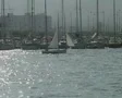 Sailing yacht moving past yachts in harbor SD Footage